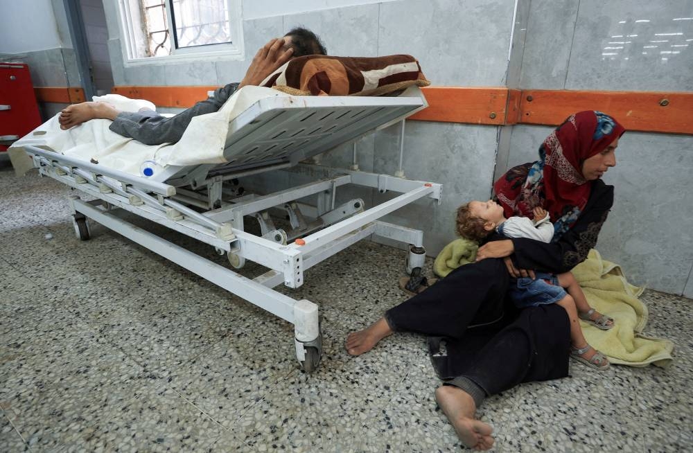 A Palestinian wounded in Israeli fire near an aid distribution center in central Gaza lies at Al-Shifa hospital, in Gaza City, on Wednesday. REUTERS