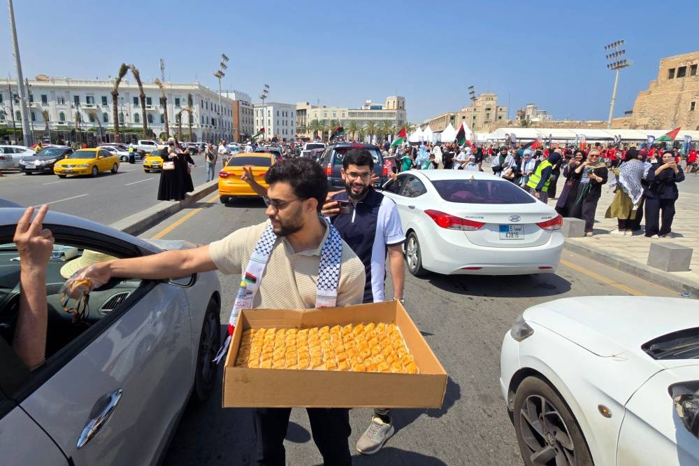Activists, heading towards Gaza by land with the aim of breaking the siege on the Palestinian territory, are greeted by Libyans in Tripoli's Martyrs Square on Wednesday, one day after crossing into Libya from Tunisia. AFP