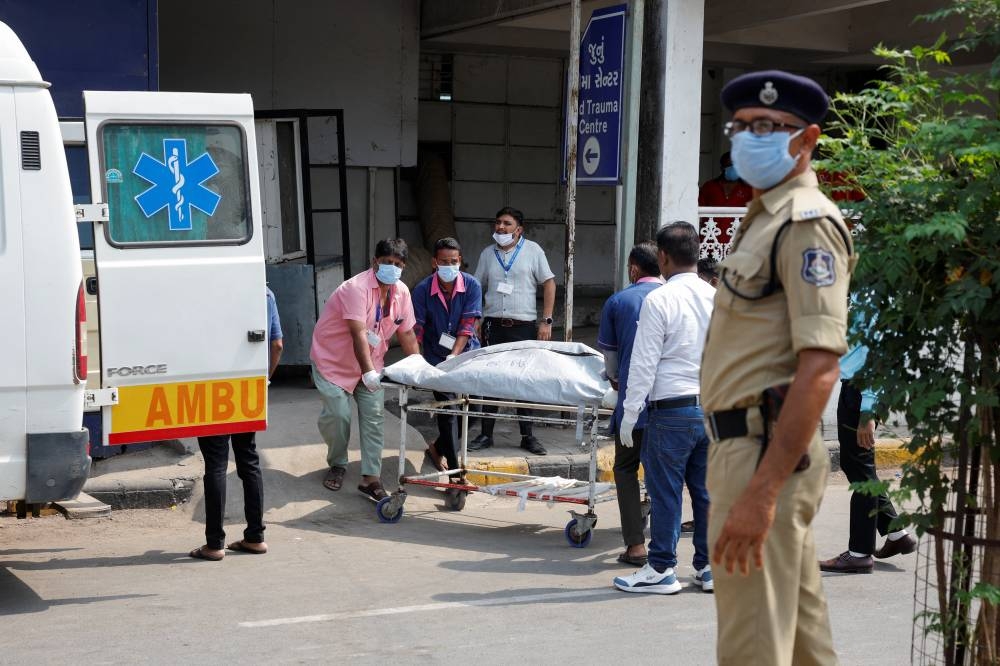 Health workers shift the body of a victim, who died in the plane crash, to a cold storage at a hospital, in the aftermath of an Air India Boeing 787-8 Dreamliner crash during take-off from an airport, in Ahmedabad, India, on Friday. REUTERS