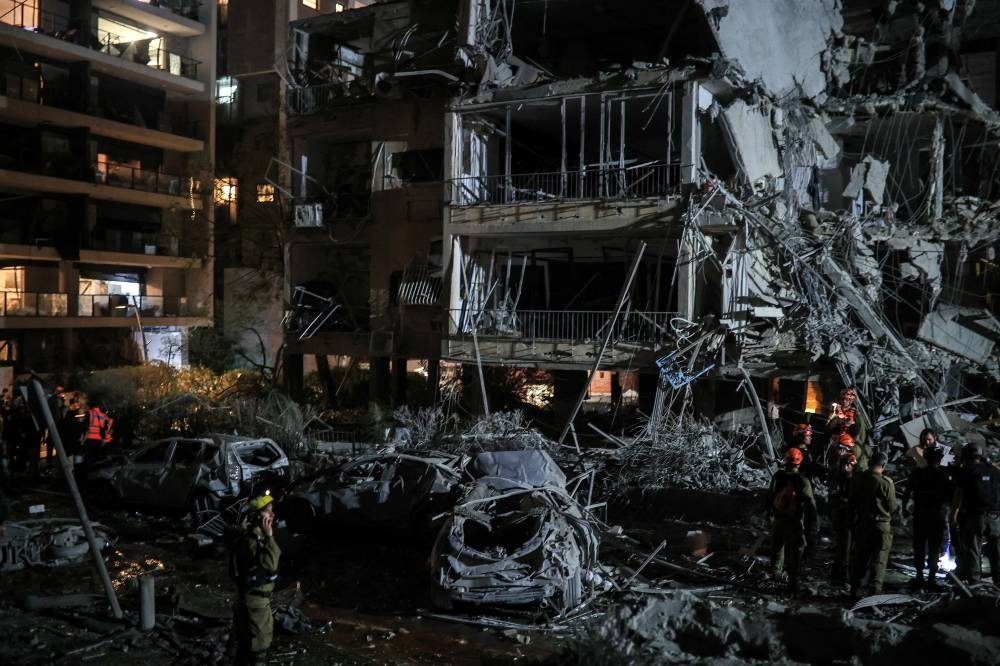 Rescue and security personnel work at an impact site following missile attack from Iran on Israel, in  Ramat Gan, Israel Friday.