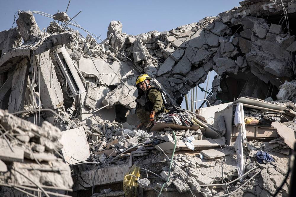Israeli emergency responders inspect a site hit by a missile fired from Iran south of Tel Aviv on Saturday. AFP