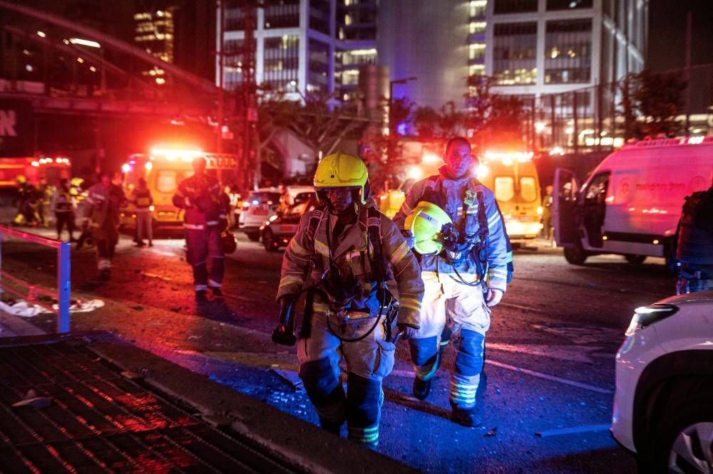 Firefighters work at an impact site following missile attack from Iran on Israel, in Tel Aviv, on Saturday. REUTERS