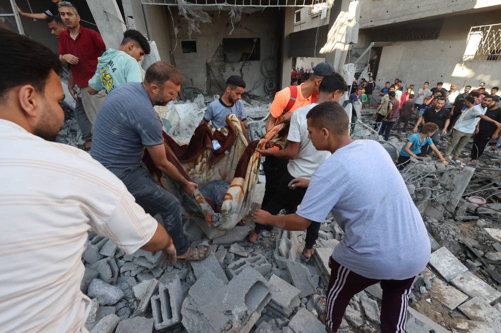 Palestinians transport a casualty pulled from the rubble of a house targeted in an Israeli strike at the al-Nuseirat refugee camp in the central Gaza Strip on Sunday. AFP