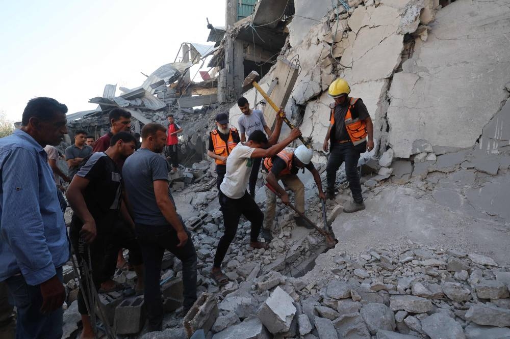 Palestinians search for casualties in the rubble of a house targeted in an Israeli strike at the al-Nuseirat refugee camp in the central Gaza Strip on Sunday. AFP
