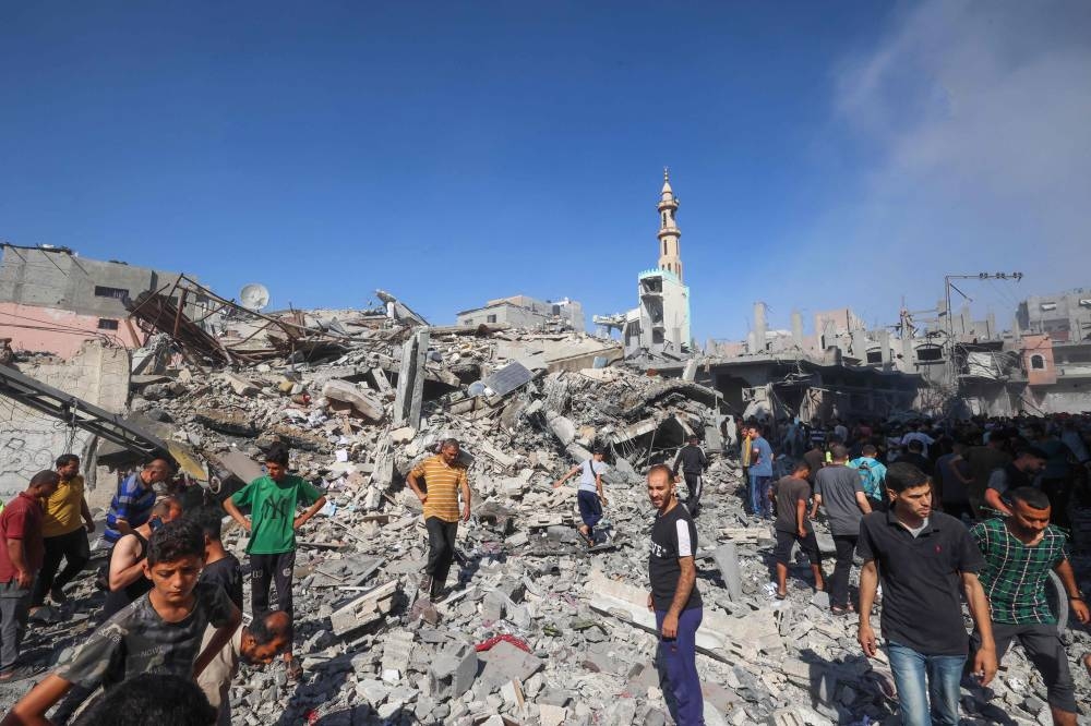 Palestinians inspect the rubble of a house hit in an Israeli strike on the Bureij camp for Palestinian refugees in the central Gaza Strip on Sunday. AFP
