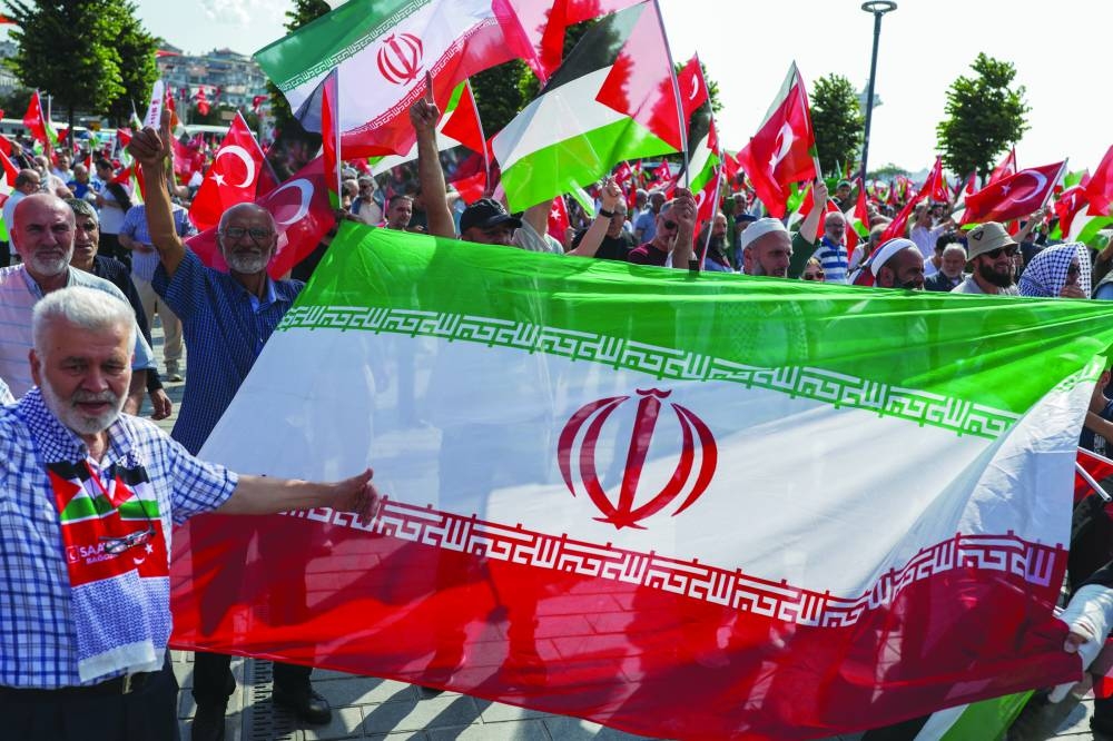 
Demonstrators hold Turkish, Iranian and Palestinian flags during a protest against Israel and to express support for Palestinians in Gaza, in Istanbul, Turkiye, yesterday. 