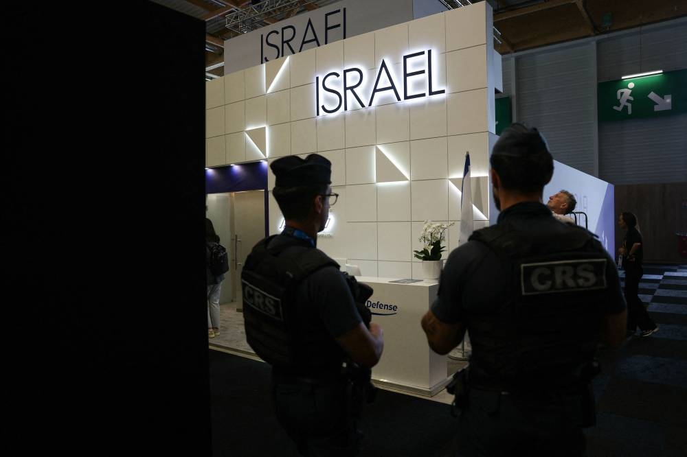 French Republican Security Corps (CRS - Compagnies Republicaines de Securite) police officers patrol in front of the closed Israeli Pavillon during the 55th edition of the International Paris Air Show at the Paris–Le Bourget Airport, in Le Bourget, suburb of Paris on Monday. AFP