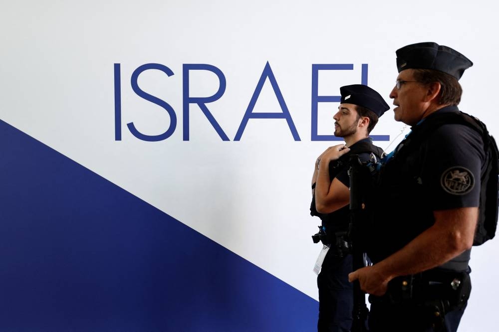 French police walk past the Israeli pavilion at the 55th International Paris Airshow at Le Bourget Airport near Paris, France, on Monday. REUTERS