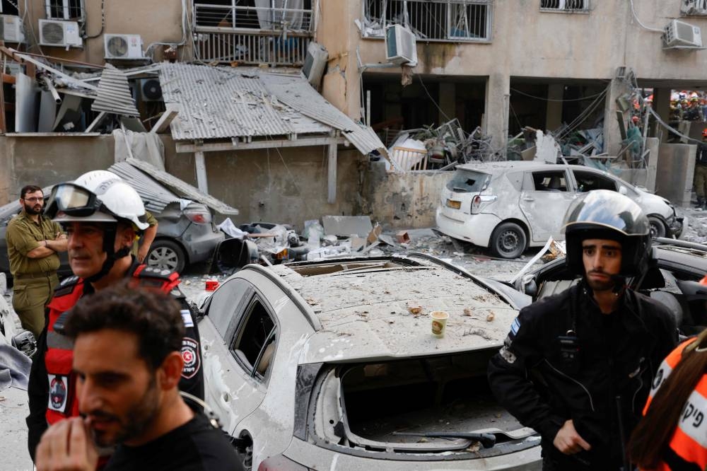 Rescuers work near a damaged building following a strike by an Iranian missile in the Israeli city of Bnei Brak, east of Tel Aviv, on Monday. AFP
