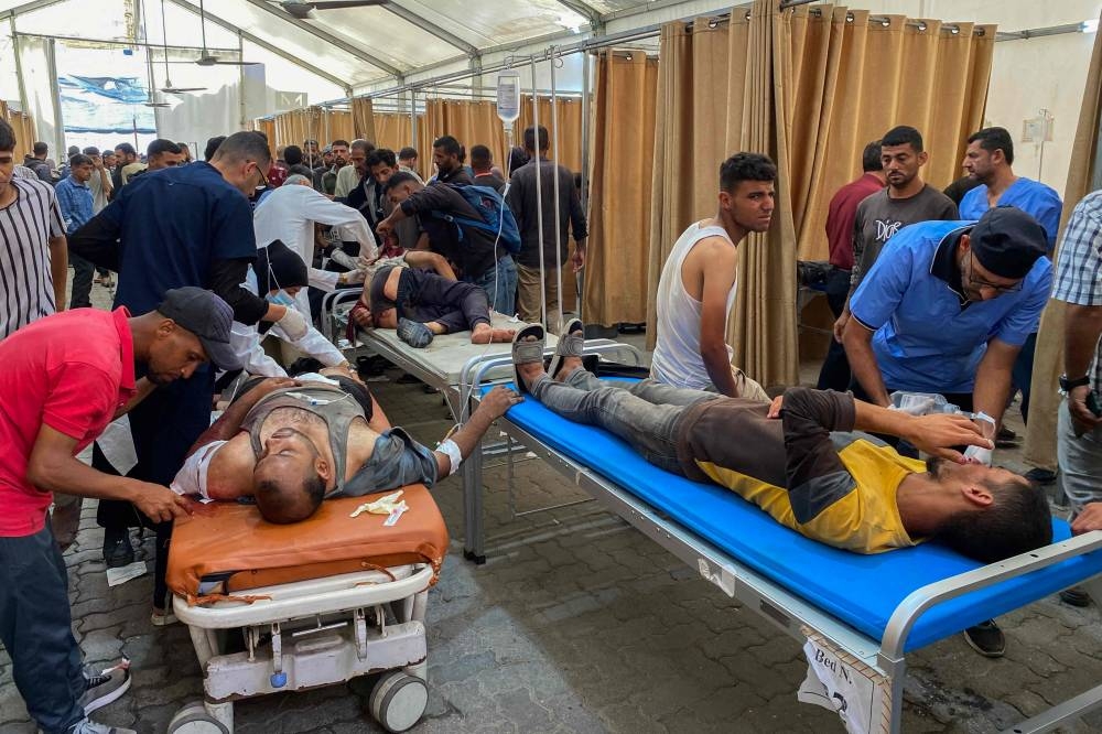 Palestinians who were injured in Israeli fire as they gathered near a food aid centre, receive care at Khan Yunis' Nasser hospital in the southern Gaza Strip, on Tuesday. AFP