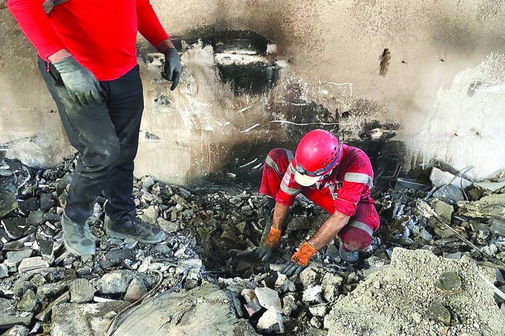 Iranian Red Crescent  members searching the debris inside a building in Tehran, targeted by Israeli strikes.