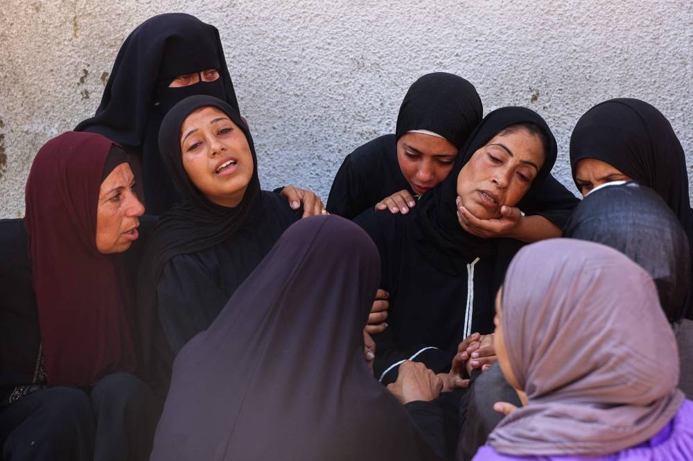 Relatives mourn Palestinians who were killed a day earlier in Israeli fire while seeking food aid, during his funeral at Al-Shifa hospital in Gaza City on Wednesday. AFP