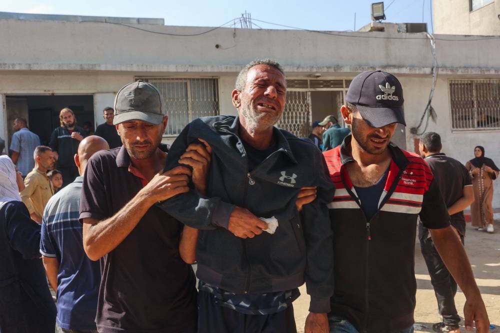 Relatives mourn Palestinians who were killed a day earlier in Israeli fire while seeking food aid, during his funeral at Al-Shifa hospital in Gaza City on Wednesday. AFP