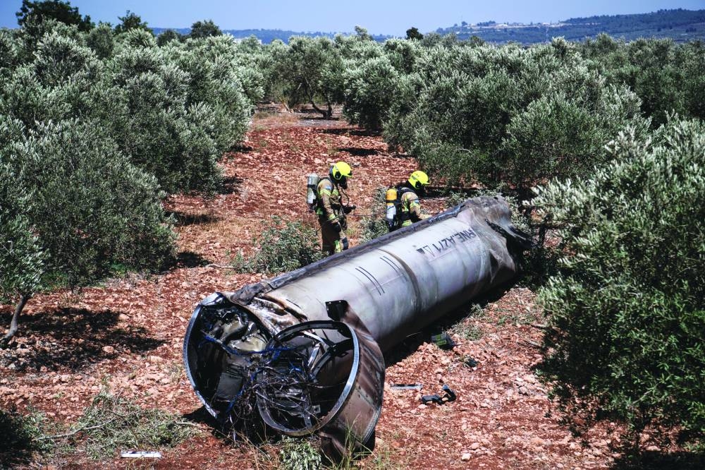 Members of the Israeli special forces check the apparent remains of an Iranian ballistic missile, in northern Israel, Wednesday.