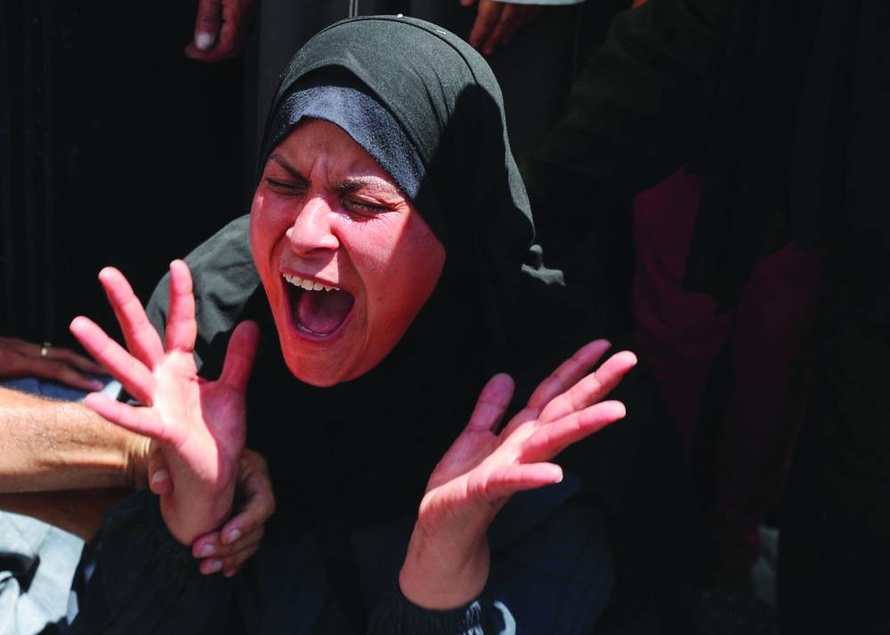 
A woman cries as victims are taken from Al-Shifa Hospital  yesterday. 