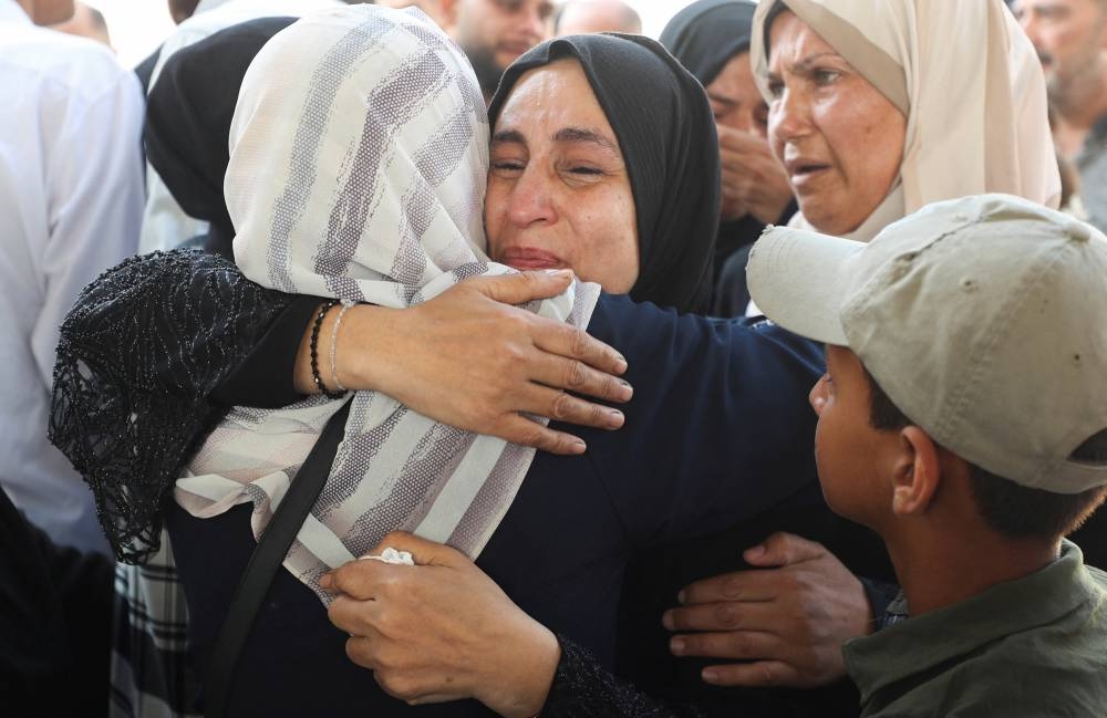 Mourners react during the funeral of Palestinians, who, according to Gaza’s health ministry, were killed in an Israeli airstrike on a house on Friday, at Al-Shifa Hospital, in Gaza City, on Saturday. REUTERS