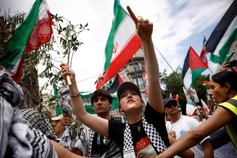 Protesters wave Palestinian and Iranian flags as they take part in a march through central London, on Saturday, at a demonstration organised by the Palestinian Solidarity Campaign. AFP
