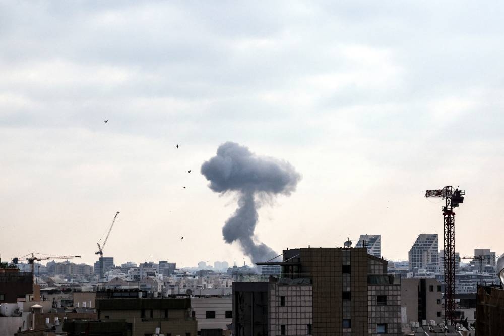 Smoke can be seen during a missile attack from Iran on Israel, in Tel Aviv, on Sunday. REUTERS