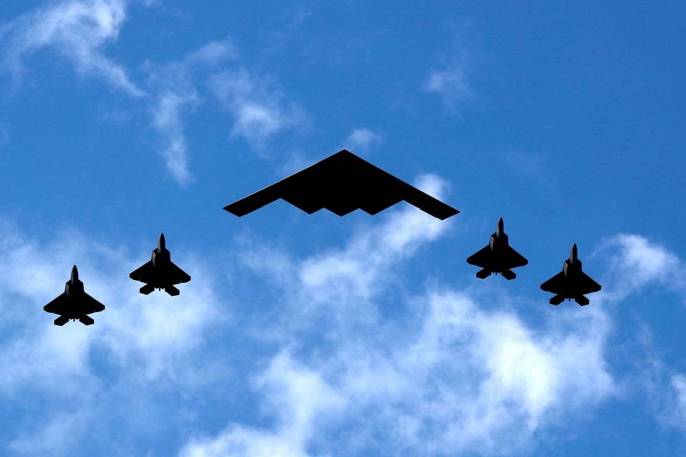 A US Air Force B-2 Spirit Stealth Bomber (C) is flanked by four F-22 Raptor fighter planes during a flyover of military aircraft down the Hudson River and New York Harbor past York City, and New Jersey, US, July 4, 2020. REUTERS/Mike Segar/File Photo