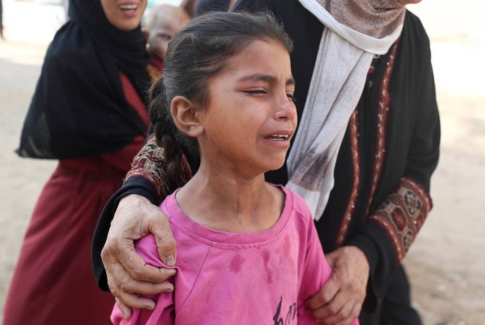 A child reacts during the funeral of Palestinians who were killed by Israeli fire while trying to receive aid in central Gaza Strip, according to the Gaza Health Ministry, at Al-Shifa hospital, in Gaza City, on Tuesday. REUTERS