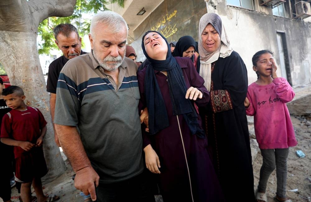 Mourners react during the funeral of Palestinians who were killed by Israeli fire while trying to receive aid in central Gaza Strip, according to the Gaza Health Ministry, at Al-Shifa hospital, in Gaza City, on Tuesday. REUTERS