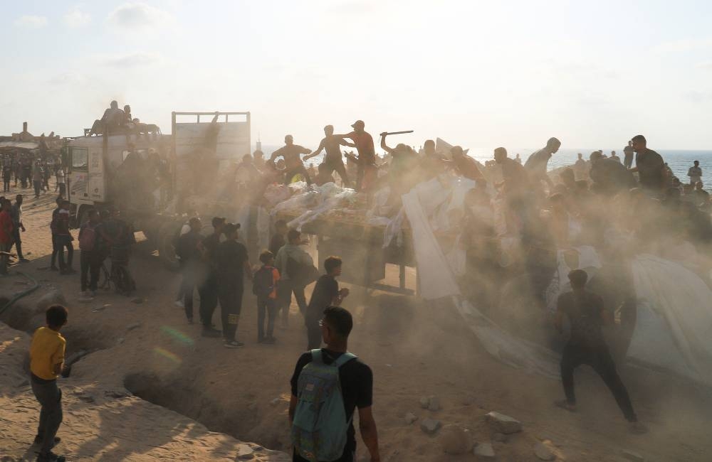 Palestinians gather to receive aid supplies in Beit Lahia, in the northern Gaza Strip, on Monday. REUTERS