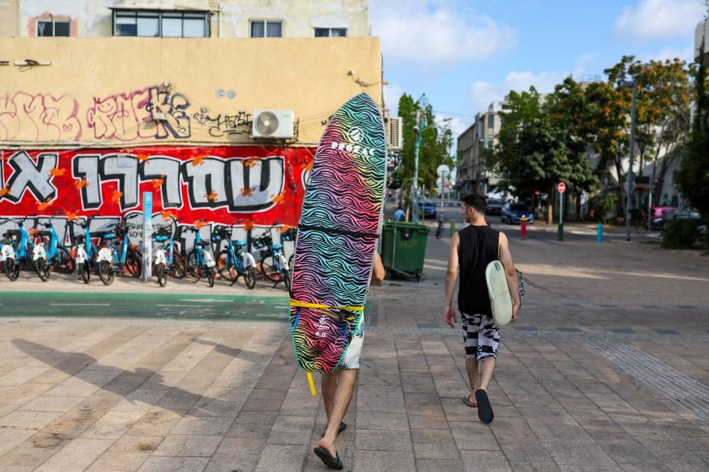 People walk, after US President Donald Trump announced a ceasefire between Israel and Iran, in Tel Aviv, Israel, on Tuesday. REUTERS 