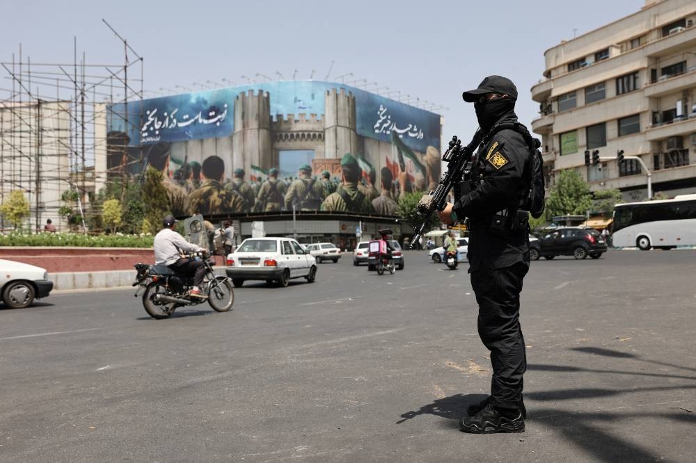 A security guard stands on a street, during early hours of ceasefire, in Tehran, Iran, on Tuesday. WANA via REUTERS 