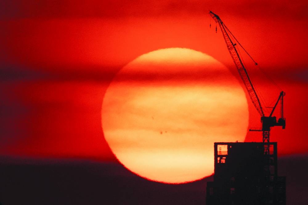 
The sun sets behind a crane in Manhattan as an extreme heat warning is in effect in New York City. (Reuters) 