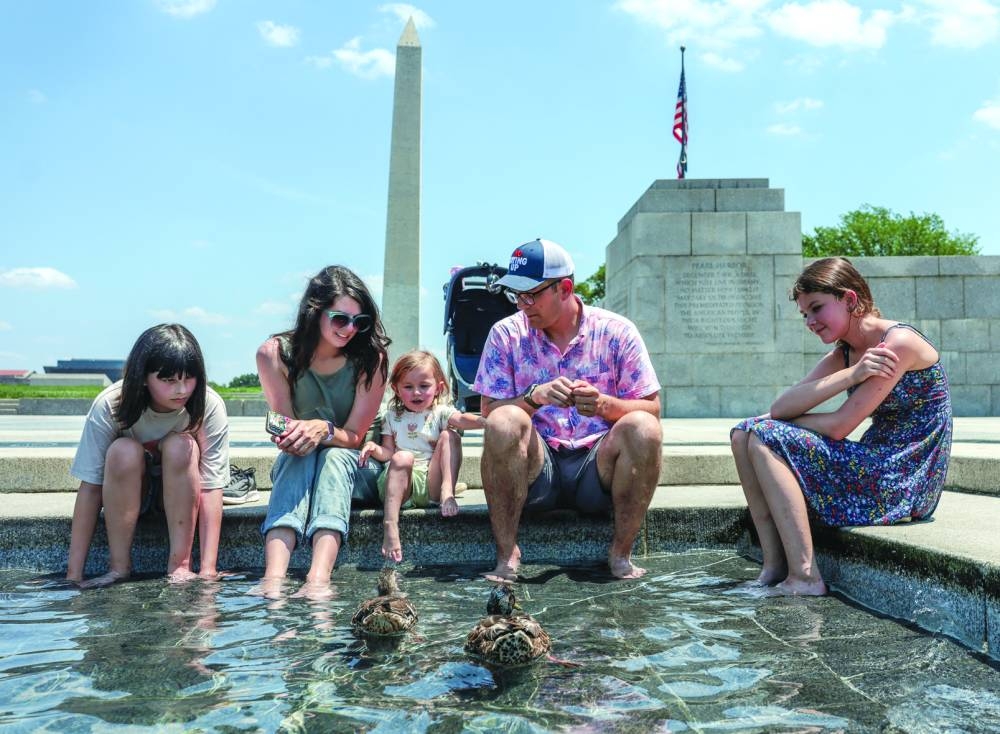 
Georgie Bailey, 3, from Greenville, South Carolina, looks at ducks as she and her family cool off in a water feature at the World War II Memorial amid a dangerous heat wave afflicting the eastern half of the United States, in Washington, yesterday. (Reuters) 
