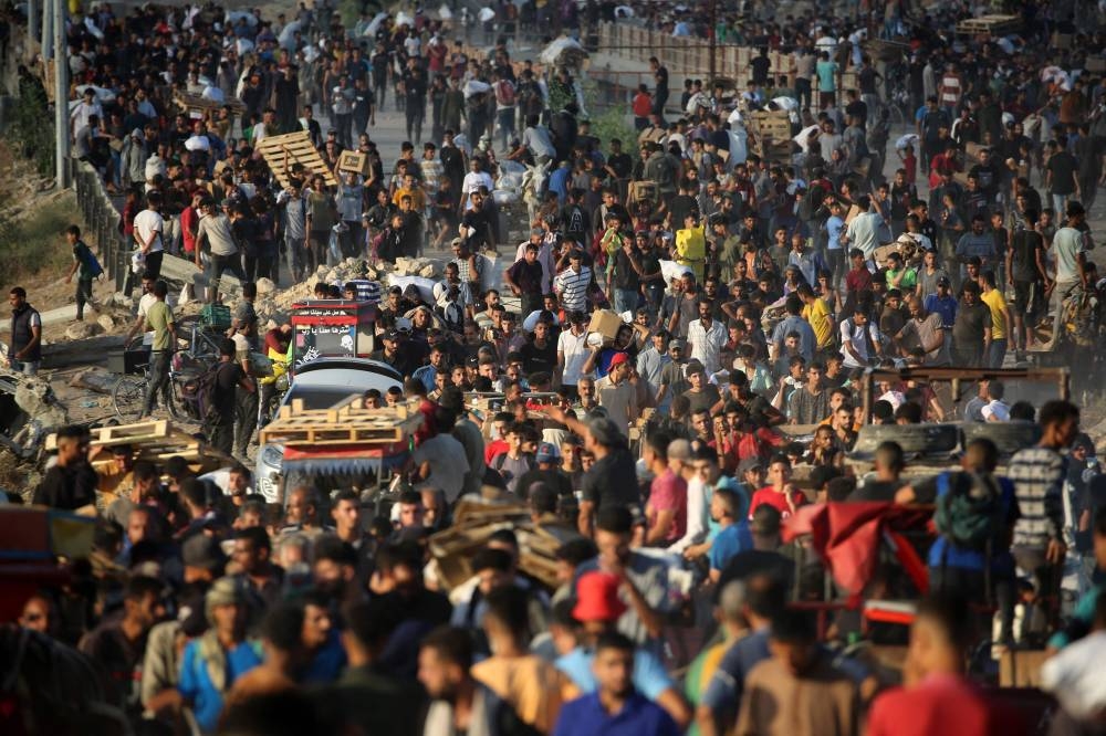 Palestinians gather at an aid distribution point set up by the privately-run Gaza Humanitarian Foundation (GHF), near the Nuseirat refugee camp in the northern Gaza Strip, on Wednesday. AFP