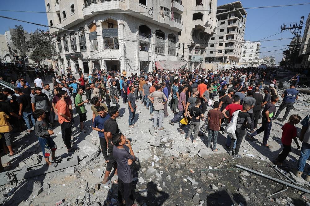 Palestinians inspect the site of an Israeli air strike on a house in Gaza City, on Friday. REUTERS