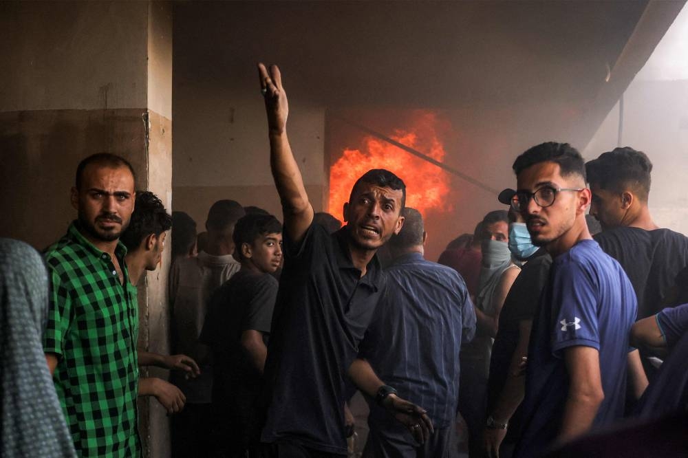 People gather outside a burning classroom during a blaze following an Israeli strike at the UNRWA's Osama bin Zaid school in the Saftawi district in western Jabalia in the northern Gaza Strip, on Friday. AFP