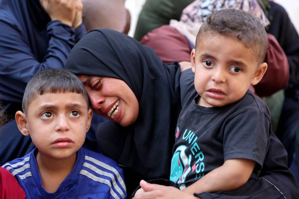 Palestinians mourn over the bodies of loved ones killed during overnight Israeli strikes, on the grounds of Al-Shifa hospital in the central Gaza Strip on Saturday. AFP