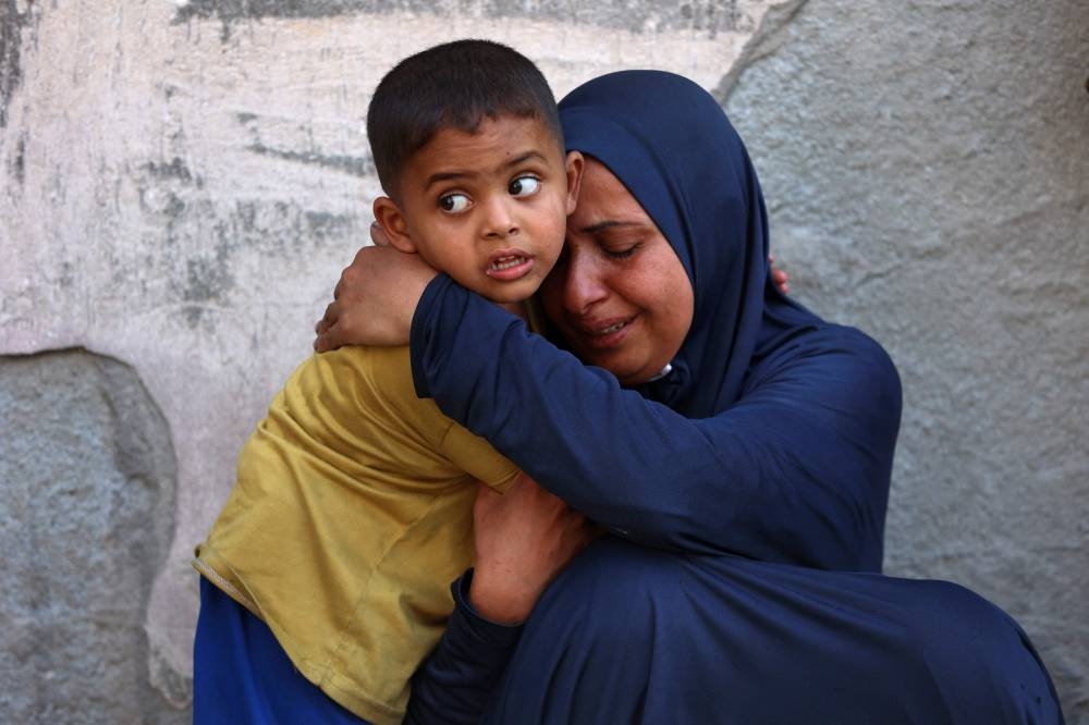 A Palestinian woman mourns near the bodies of loved ones killed during overnight Israeli strikes, on the grounds of Al-Shifa hospital in the central Gaza Strip on Saturday. AFP