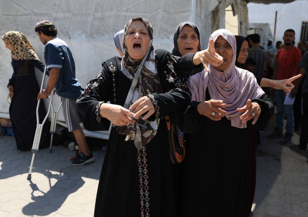 Palestinian women react upon the arrival of their relatives among the casualties of an Israeli air strike, according to Gaza’s health ministry, at Al-Ahli Arab Hospital in Gaza City, on Sunday. REUTERS