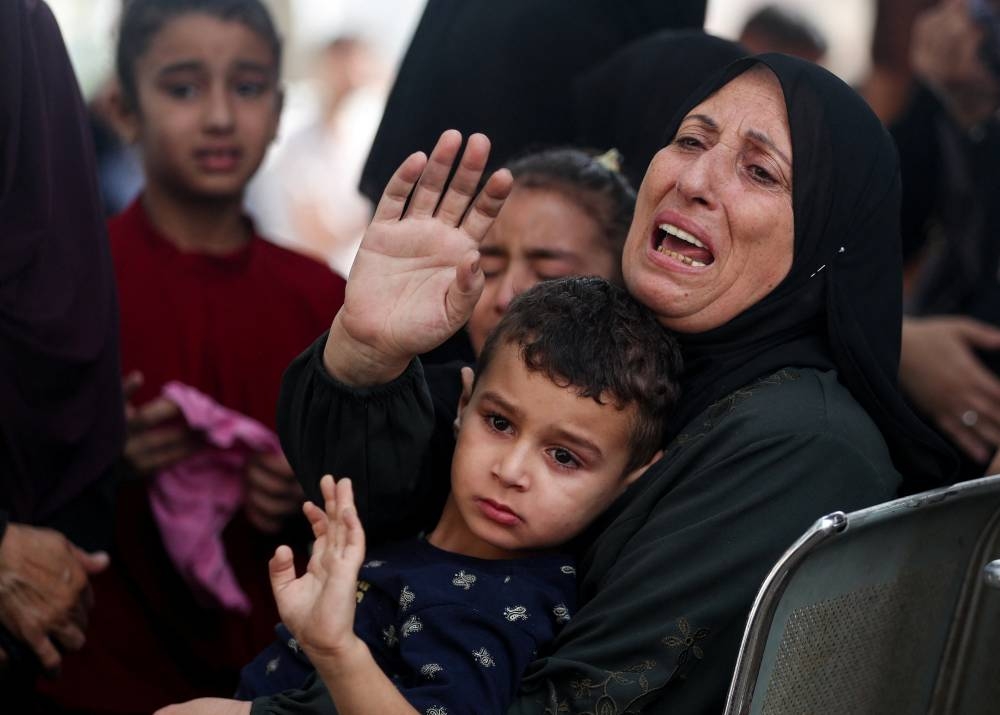 People mourn Palestinians killed in Israeli strikes on Monday, according to Gaza's health ministry, during their funeral at Al-Shifa Hospital in Gaza City,Tuesday. REUTERS