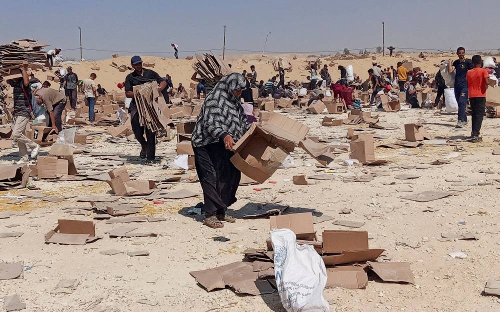 Palestinians gather to collect what remains of relief supplies from the distribution center of the US-backed Gaza Humanitarian Foundation, in Rafah, in the southern Gaza Strip, June 5, 2025. REUTERS