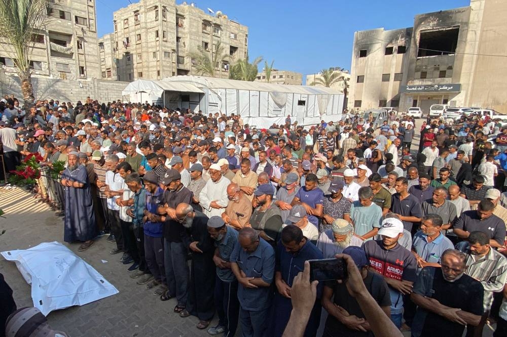 Mourners pray during a funeral of displaced Palestinians, killed in an Israeli strike on a camp for the internally displaced, at Khan Yunis' Nasser hospital in the southern Gaza Strip on Wednesday. AFP