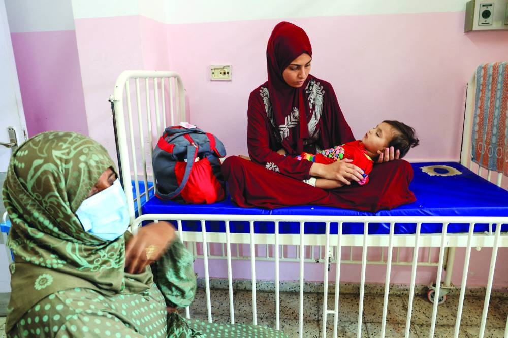 A Palestinian woman holds her child, who is infected with meningitis, at Nasser Hospital in southern Gaza Strip,Thursday 