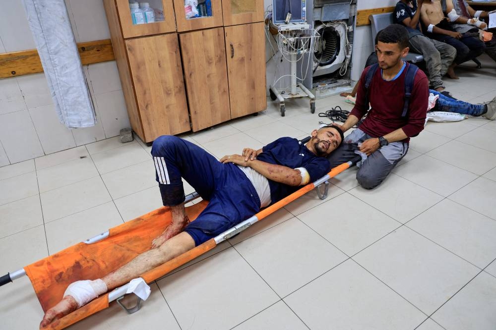 A Palestinian, wounded by Israeli fire while seeking aid on Friday, according to medics, lies on a stretcher at Nasser Hospital in Khan Younis, southern Gaza Strip, on Friday. REUTERS