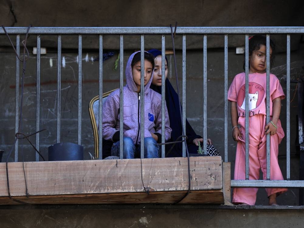 Palestinian children look out from a balcony at an UNRWA school sheltering displaced people that was hit in an an overnight Israeli strike, in Gaza City, on Saturday. REUTERS