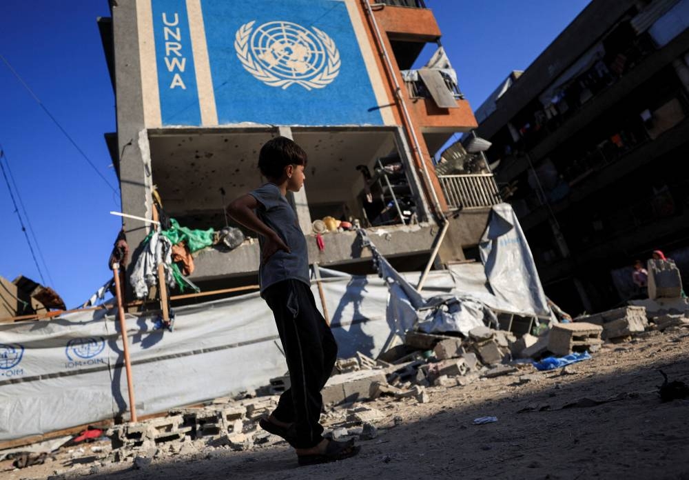 A Palestinian boy walks near an UNRWA school sheltering displaced people that was hit in an an overnight Israeli strike, in Gaza City, on Saturday. REUTERS