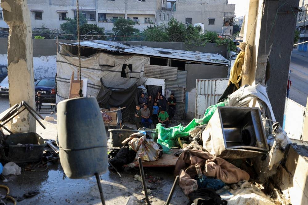 Palestinians inspect the damage at an UNRWA school sheltering displaced people that was hit in an an overnight Israeli strike, in Gaza City, on Saturday. REUTERS