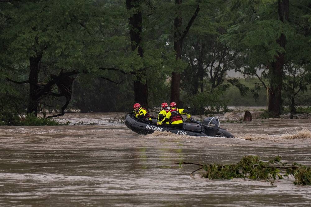Boerne Search and Rescue teams navigate upstream in an inflatable boat on the flooded Guadalupe River on Friday in Comfort, Texas. 