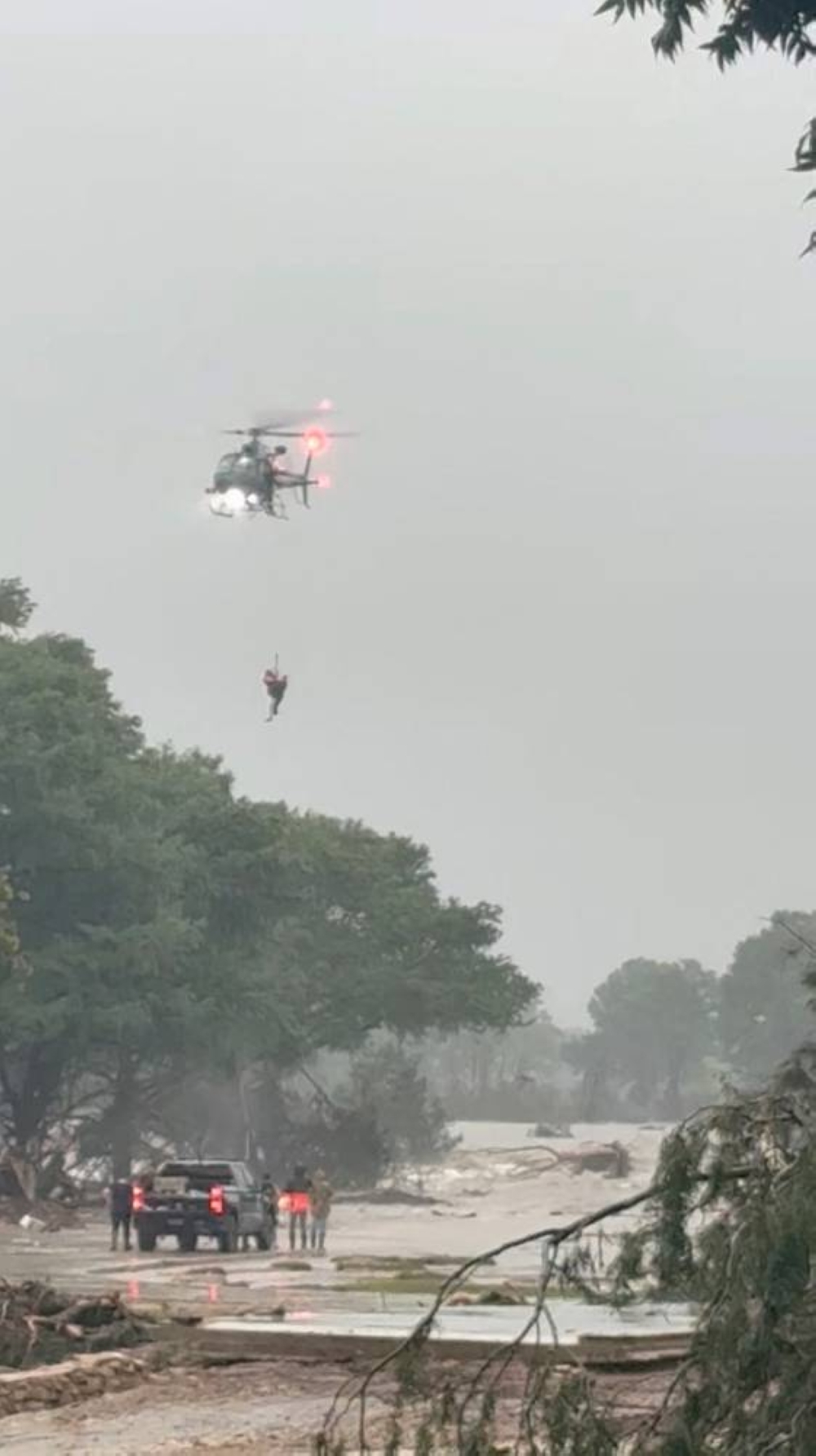 A helicopter rescue takes place amid the deadly flooding in Kerrville, Texas, on Friday,