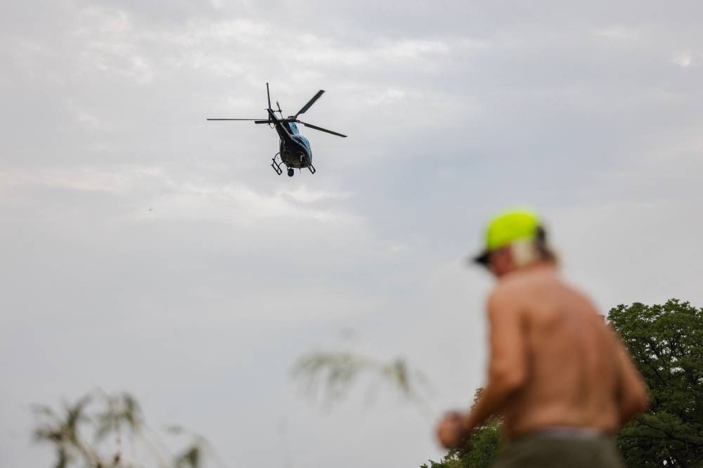 A helicopter flies over the Guadalupe River on Sunday in Center Point, Texas. AFP