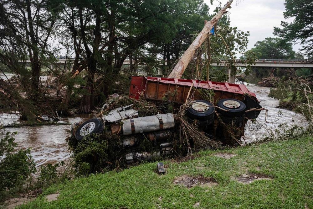A large truck is impaled onto a tree after flash flooding on the bank Guadalupe River on Sunday in Center Point, Texas. AFP