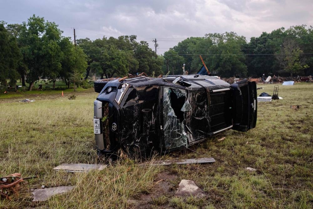 A destroyed SUV lays in a field after flash flooding swept through the area on Sunday in Hunt, Texas. AFP