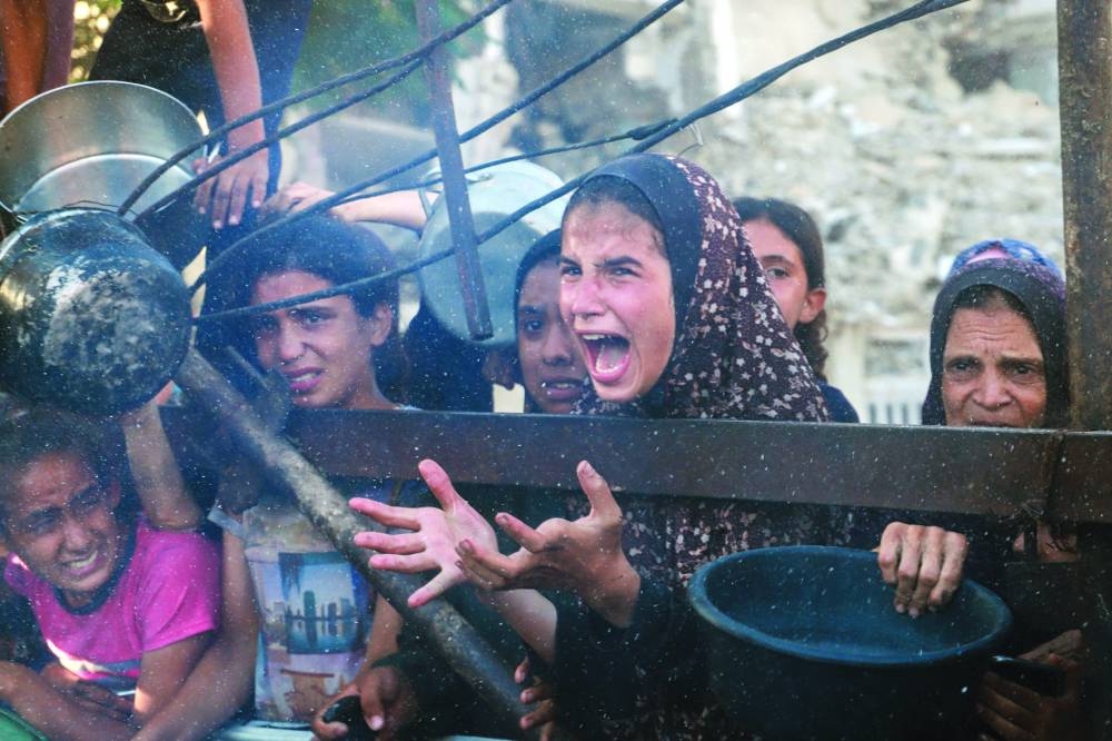 A Palestinian girl reacts as she asks for food from a charity kitchen, in Gaza City, Monday.